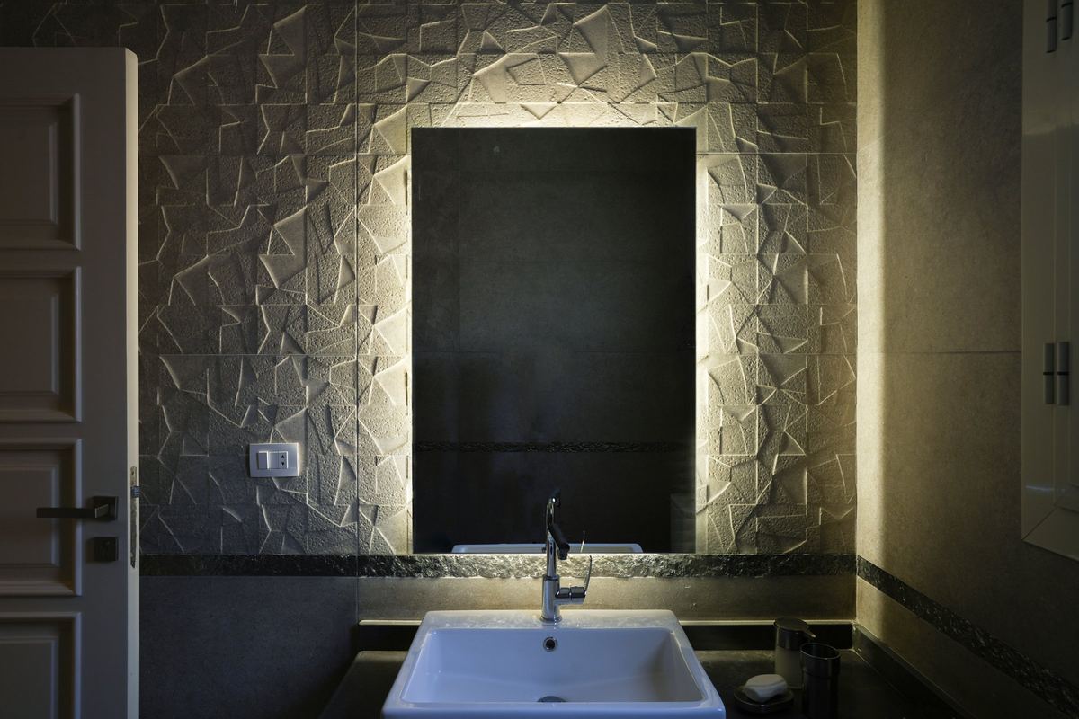 L-Villa bathroom: 3D wall tiles, backlit mirror and a vessel basin