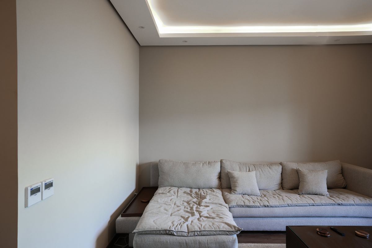 The family room as delivered: corner sofa under a lit ceiling cove