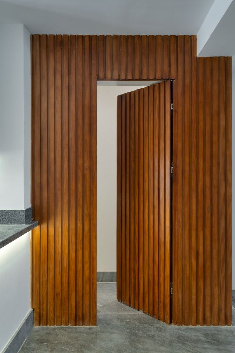 M-Villa hidden door closed: flush with the full-height timber slat wall