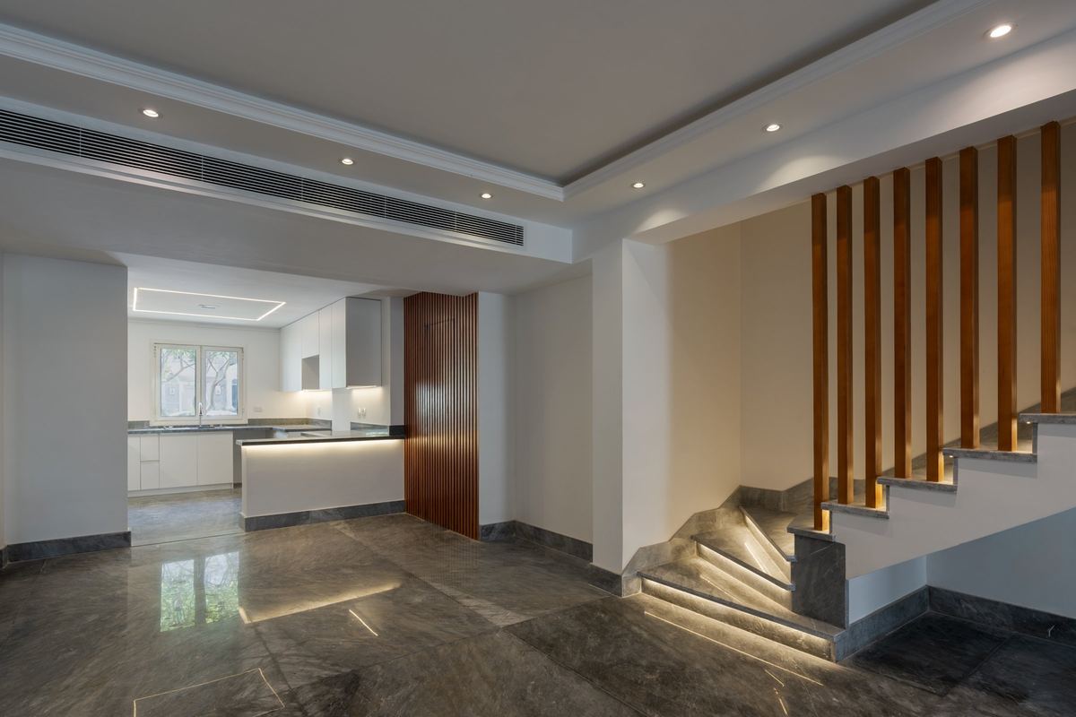 M-Villa open-plan ground floor: marble floor, kitchen and the slatted staircase