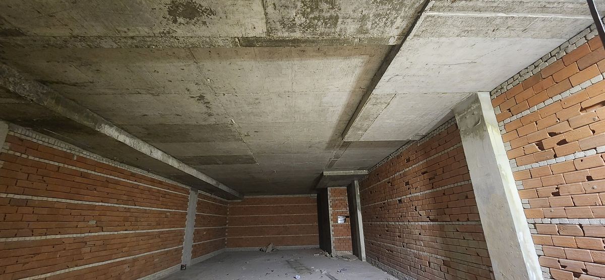Before: Polysh before fit-out: bare concrete shell with brick walls