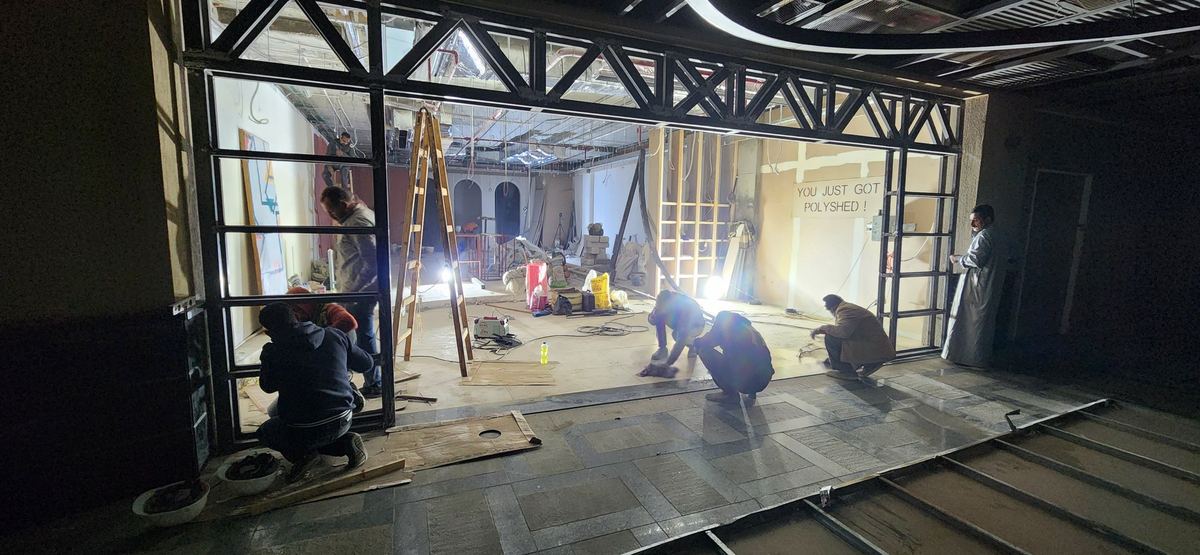 During: The Polysh glass shopfront frame going in while the team works inside at night