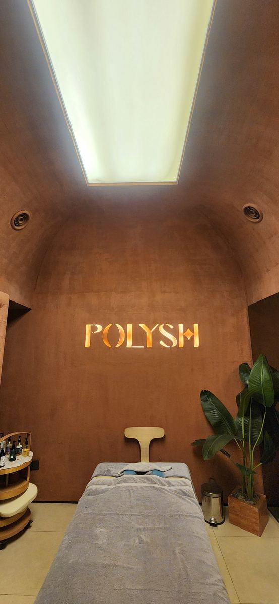 The vaulted massage room as delivered: skylight, POLYSH sign and massage bed
