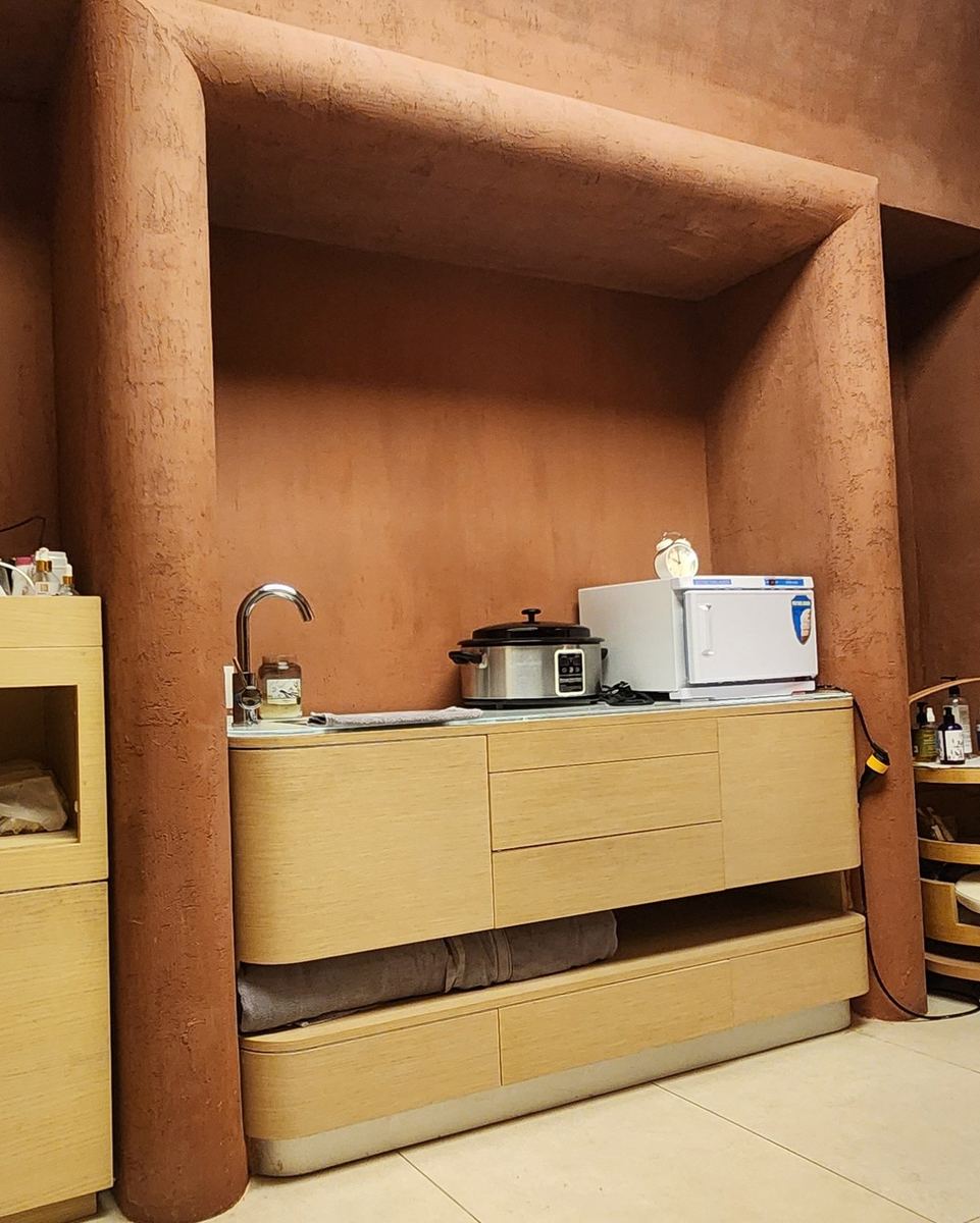 Polysh massage room: the rounded terracotta alcove with the timber sink unit