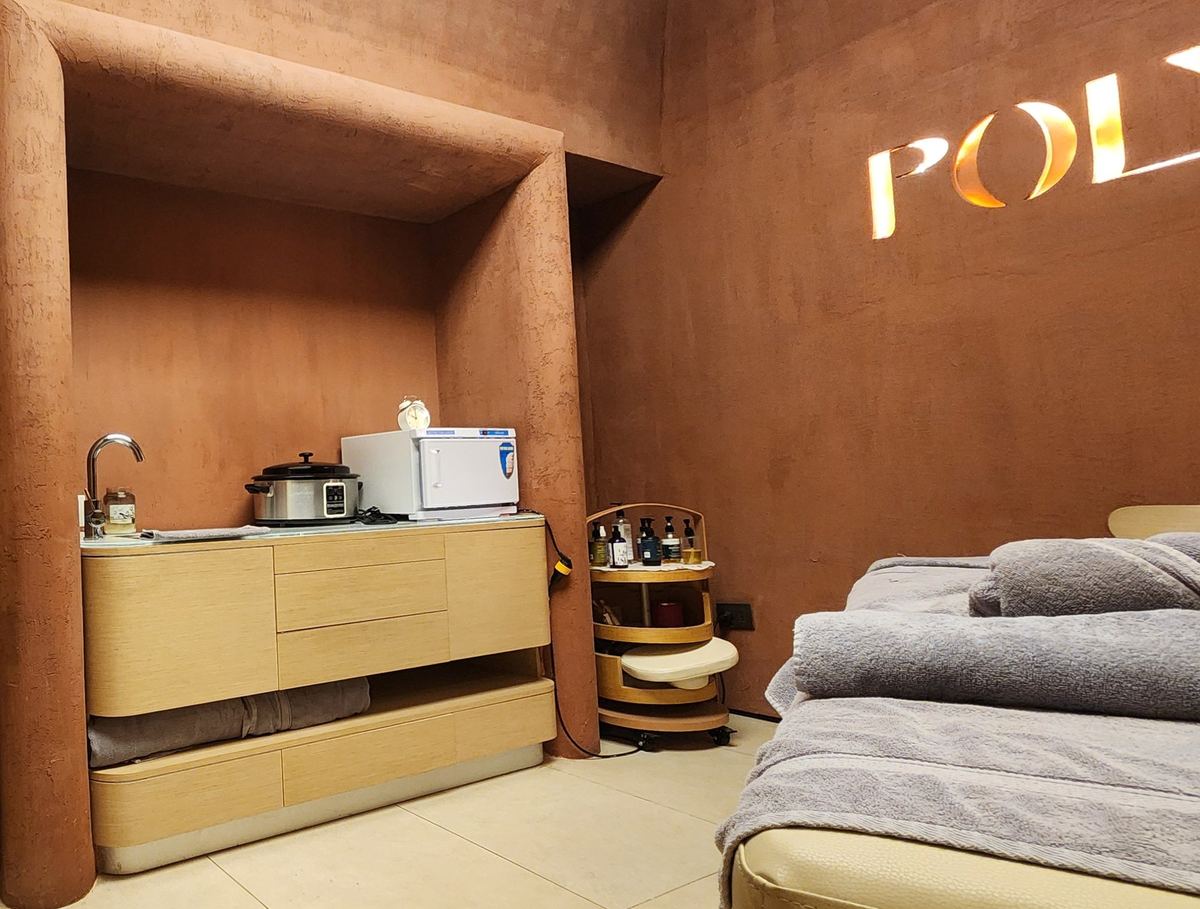 The massage room as delivered: rounded terracotta alcove with the sink unit, massage bed on the right