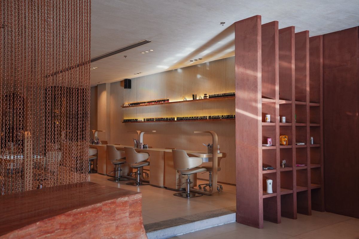 As delivered: the reception desk and the terracotta shelving column, nail bar beyond