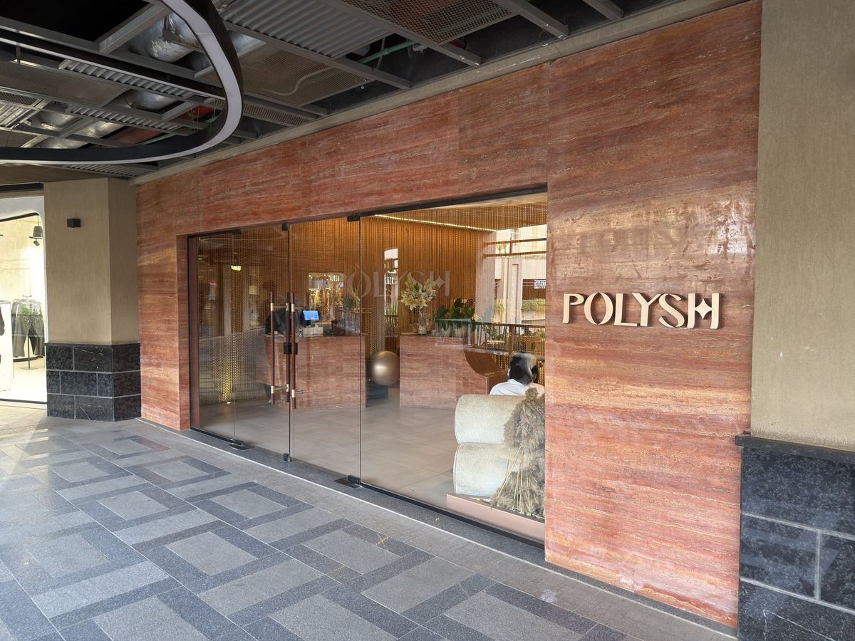 After: Polysh shopfront: glass façade and the Polysh sign on a terracotta wall