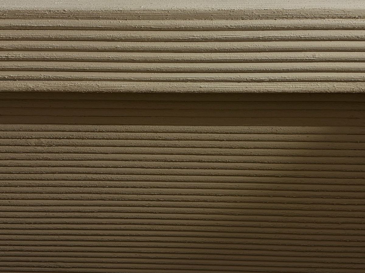 Polysh detail: fluted sand-coloured plaster wall, lines running across