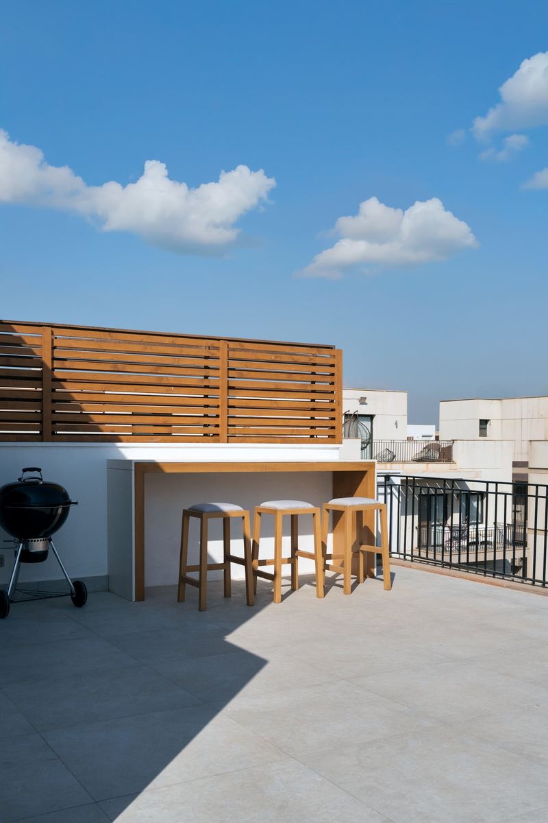 The terrazzo bar as delivered, with stools against the timber screen