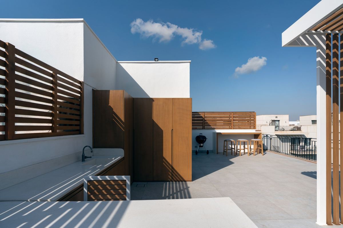 Sodic rooftop: white walls, outdoor kitchen counter and timber screens