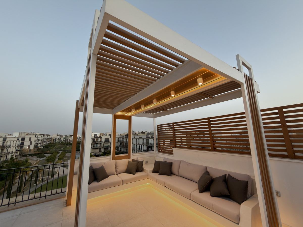 After: Sodic rooftop at dusk: pergola and built-in lounge with hidden LED lighting